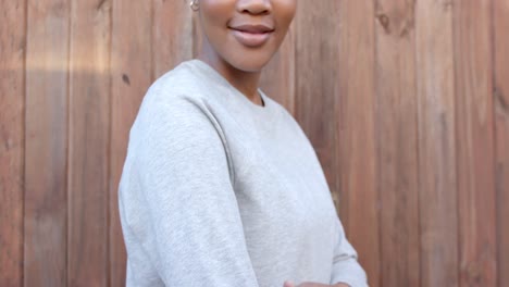 Happy-african-american-woman-in-grey-sweatshirt-touching-sleeve,-slow-motion,-copy-space