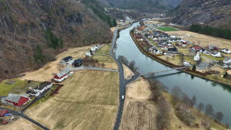 White-van-drive-towards-suspension-bridge-in-Modalen-Norway,-aerial