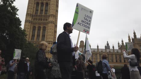 climate change protestors lobby outside parliament and along the thames with placards