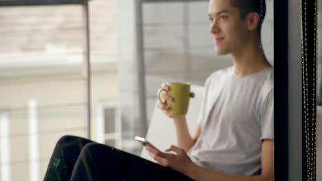 man using mobile phone while having coffee at home 4k