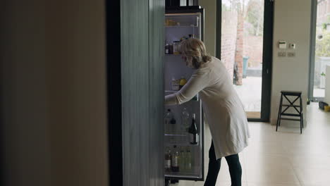 woman checking food in refrigerator