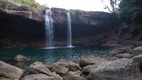 Prístina-Cascada-Rocosa-Natural-Que-Cae-Desde-La-Cima-De-La-Montaña-Por-La-Mañana-Desde-Un-Video-De-ángulo-Plano-Tomado-En-Krangsuri-Fall-Meghalaya-India