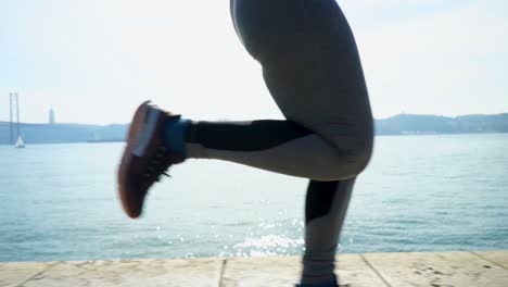 low section of sporty girl running near river