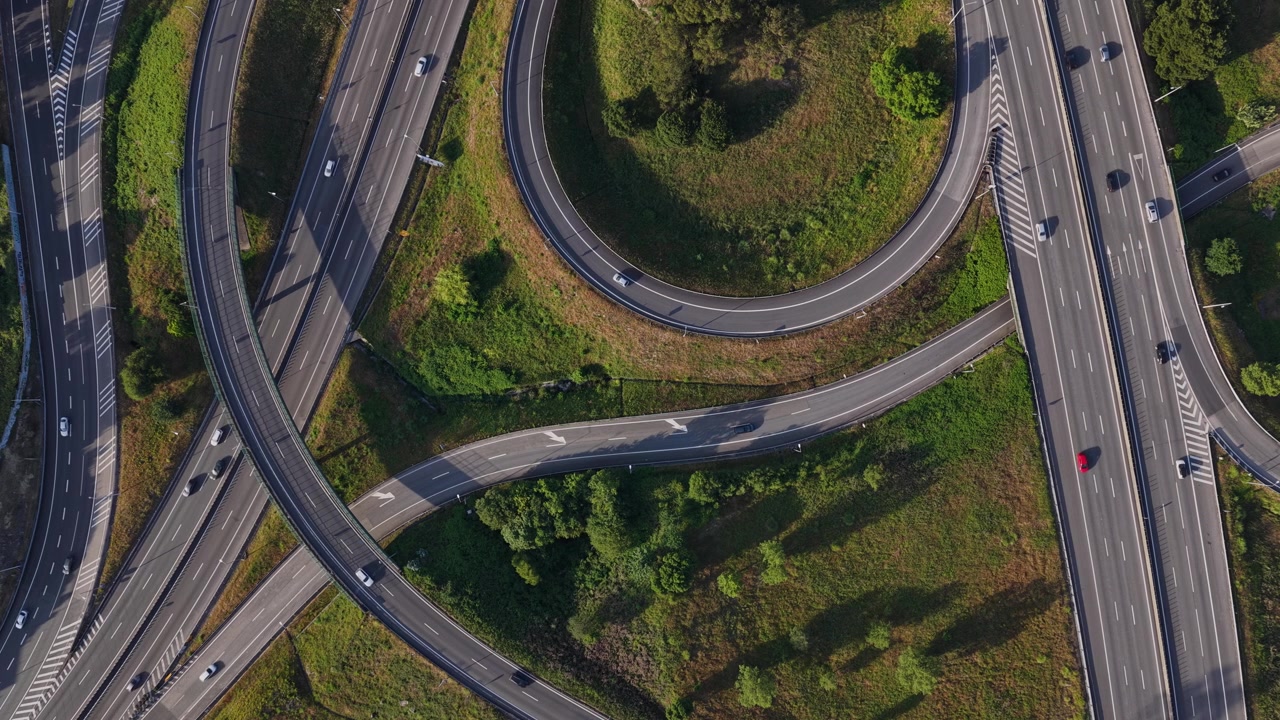 Drone shot of highway intersechanges with a lot of viaducts and cars during rush hour at sunset