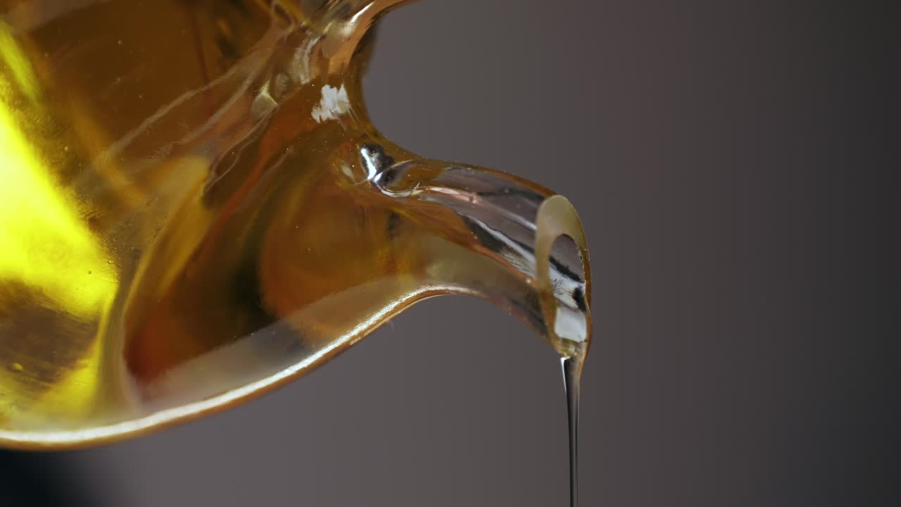 Olive Oil Pouring from a Glass Bottle
