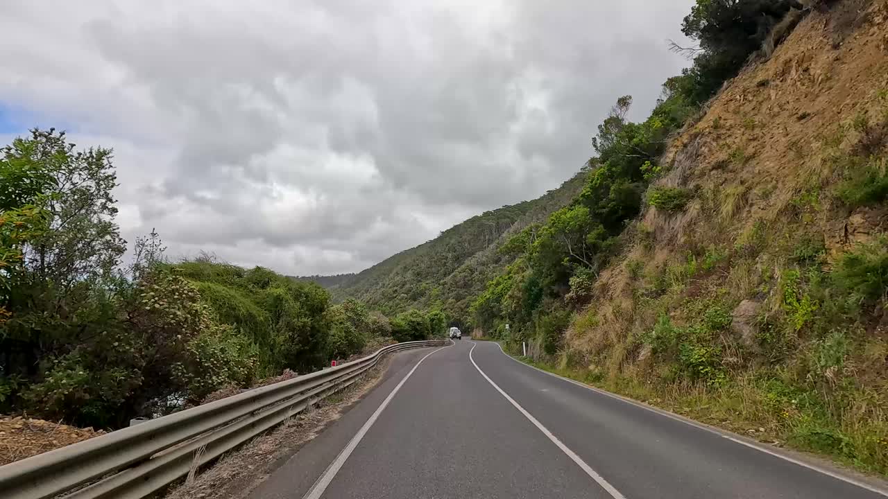 A 15-second video capturing a drive along the lush, winding Great Ocean Road under cloudy skies