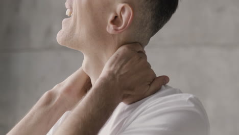 close up of a suffering man having neck pain at home