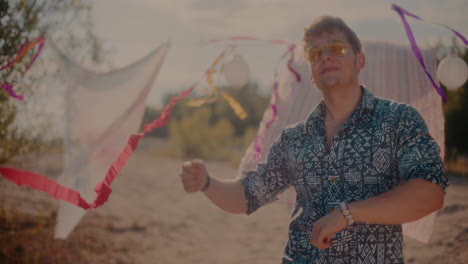 Smiling-attractive-man-enjoying-music-while-grooving-at-beach