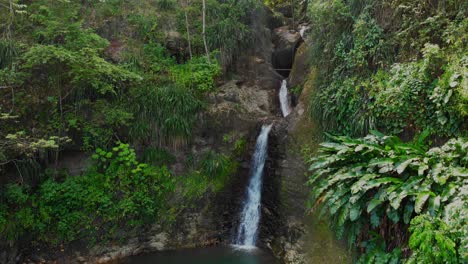 aerial footage of the source of a waterfall coming from inside the mountain on the caribbean island of grenada