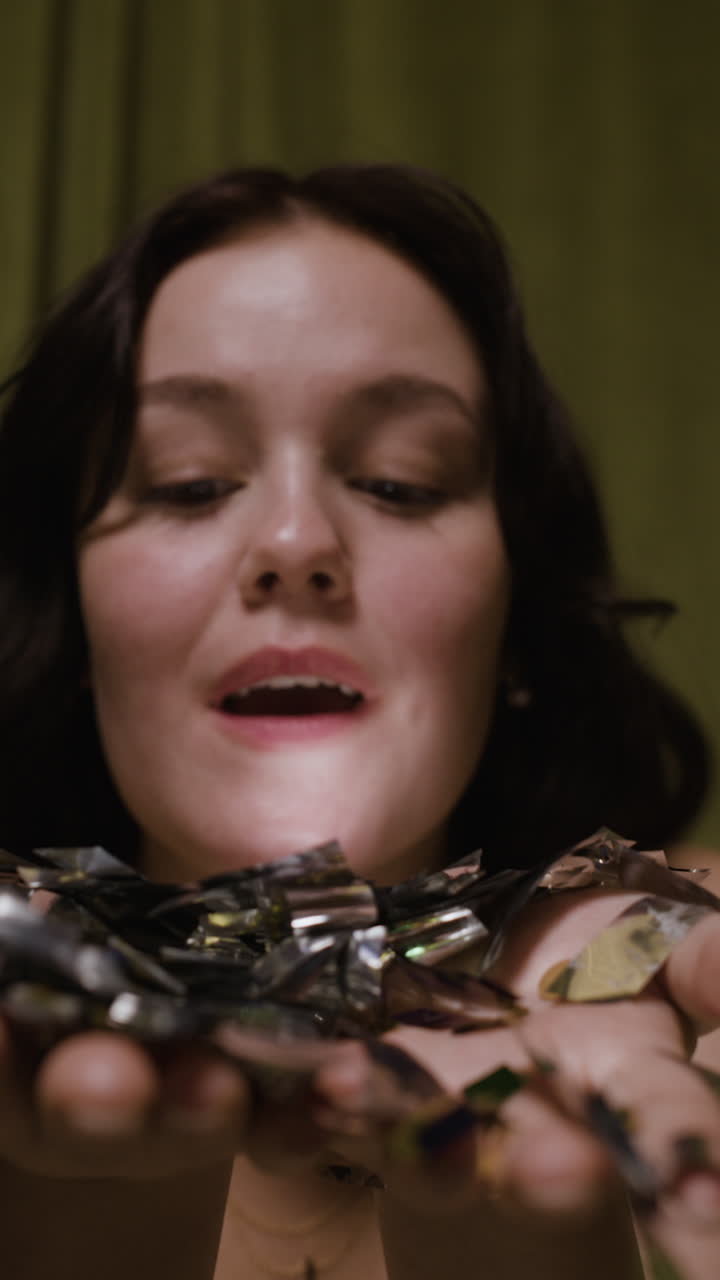 una mujer soplando confeti.