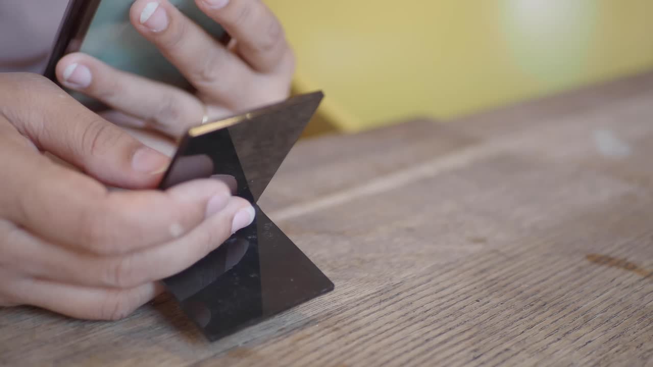 Hands holding a black square