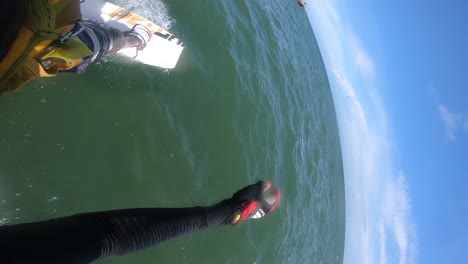 kitesurf extremo en el agua del océano cerca del barco de pesca, disparo vertical de punto de vista