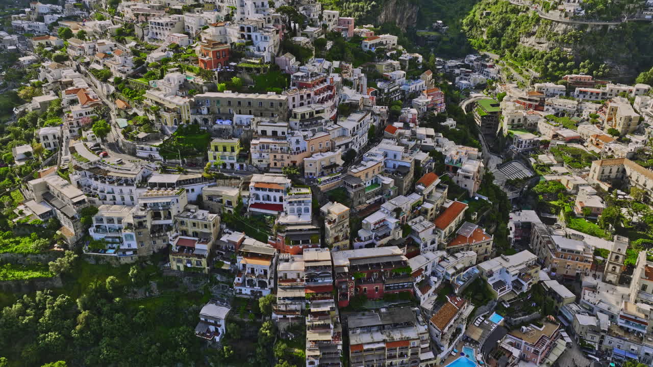 Positano Italy Aerial v3 birds eye view, flyover coastal cliffside town capturing charming neighborhood, narrow streets and terraced buildings with colorful facade - Shot with Mavic 3 Cine - May 2023
