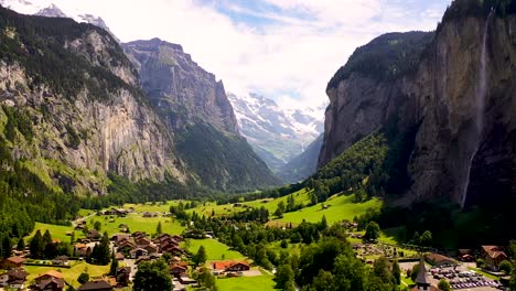 Scenic-aerial-view-:-Lauterbrunnen-valley-in-Switzerland-on-a-sunny-day,-famous-tourist-destination,-Swiss-alpine-village-with-Staubbach-waterfall-,-pine-trees-mountains-and-Picturesque-green-meadows