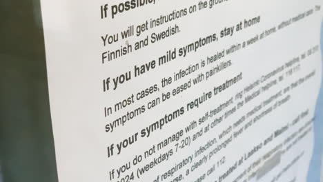 coronavirus note on a information glass, at a healthcare station - covid-19, stay at home, flatten the curve - handheld view