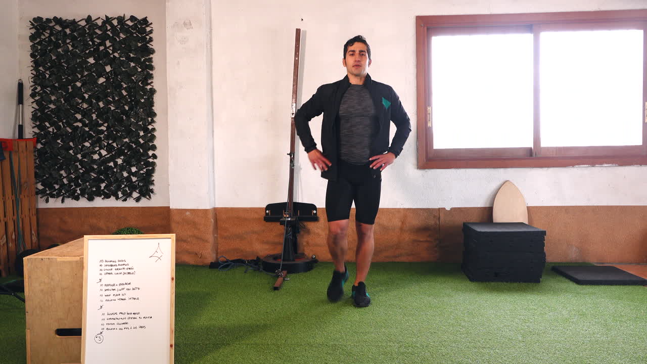 entrenador realizando estocadas con la pierna derecha y mirando la cámara durante la clase en línea