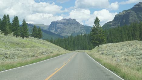 open road through car window while driving in national park landscape