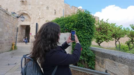 woman taking a picture of jerusalem old city