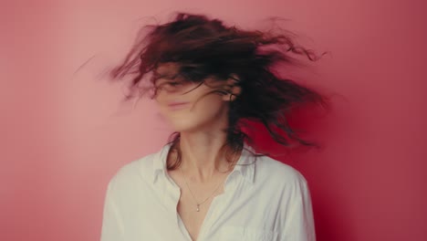 woman with motion blur hair against pink background