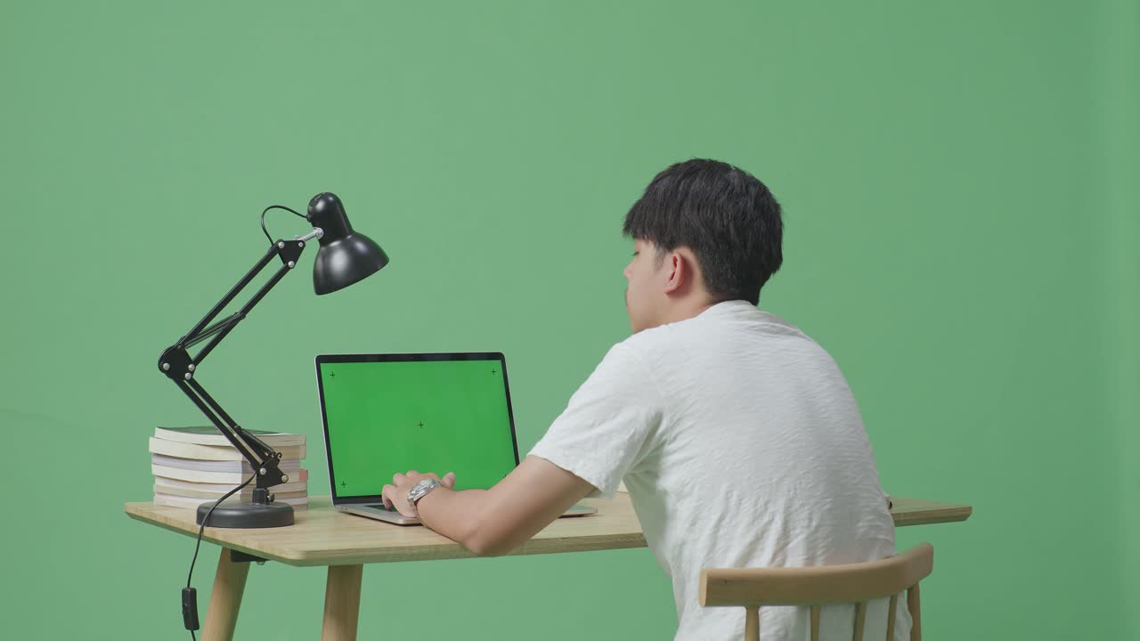 녹색 화면으로 노트북을 사용하는 사람