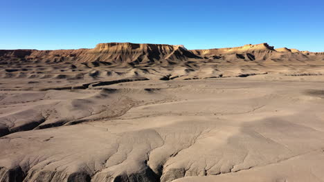 Luftaufnahme-Von-Badlands-Mit-Blauem-Himmel-Im-Hintergrund-In-Wayne-County,-Utah,-Vereinigte-Staaten