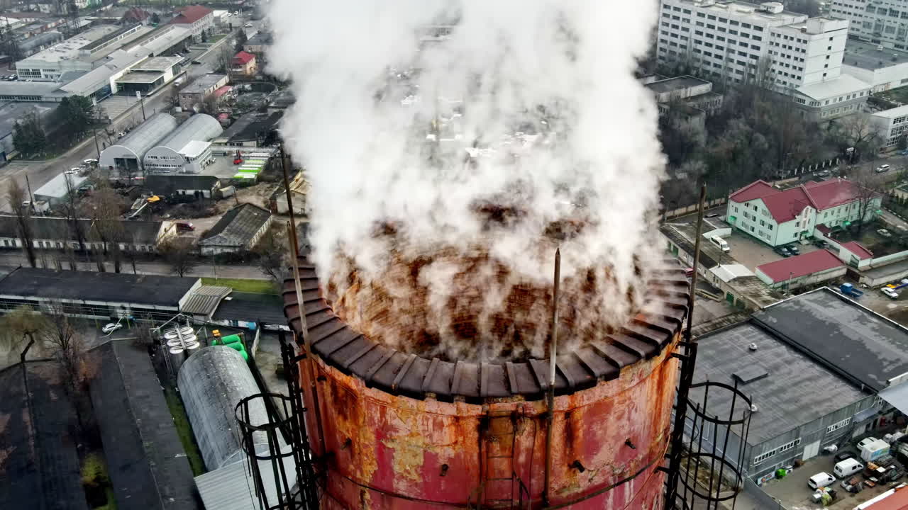 Aerial drone view of Chisinau. Tube of the thermal station with smoke coming out. Cityscape on the background. Cloudy weather. Moldova