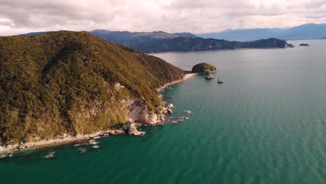 granite cliffs at whariwharangi bay and taupo point aerial reveal shot