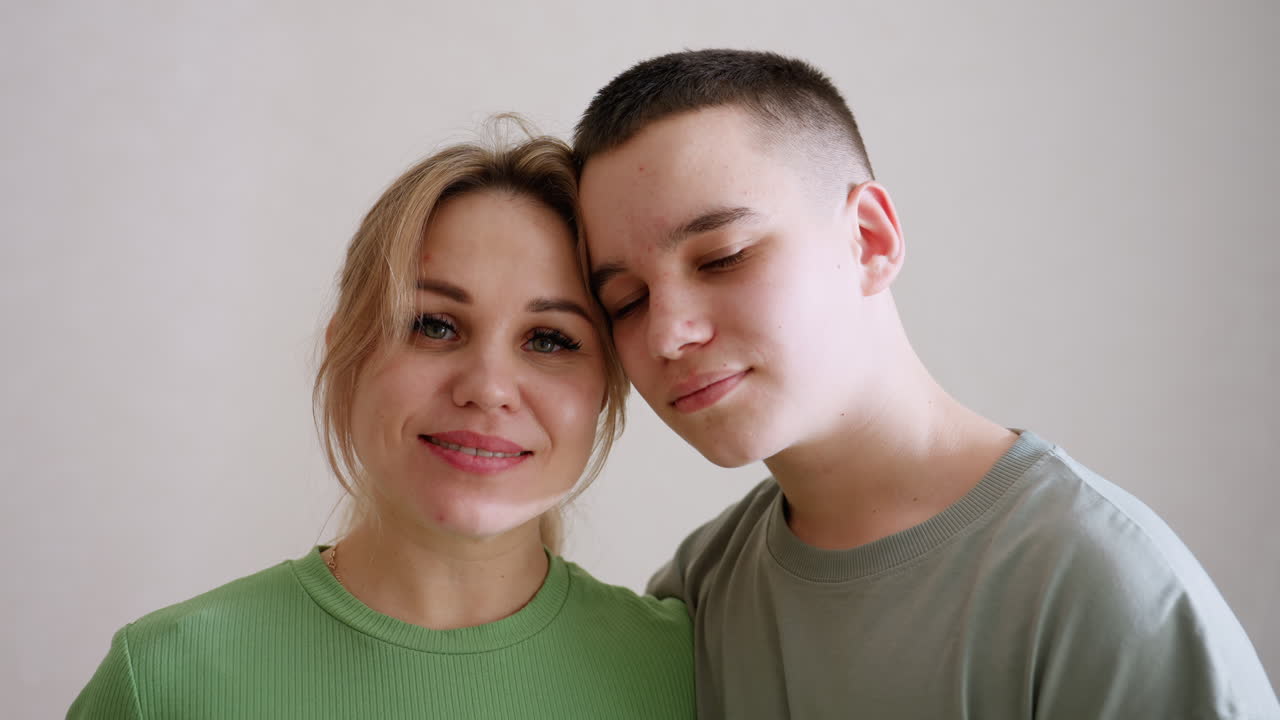 Guardian and son stand close smiling warmly, faces leaning together with gentle affection, soft indoor light highlights bond of trust, joy, and love, capturing natural moment of family togetherness