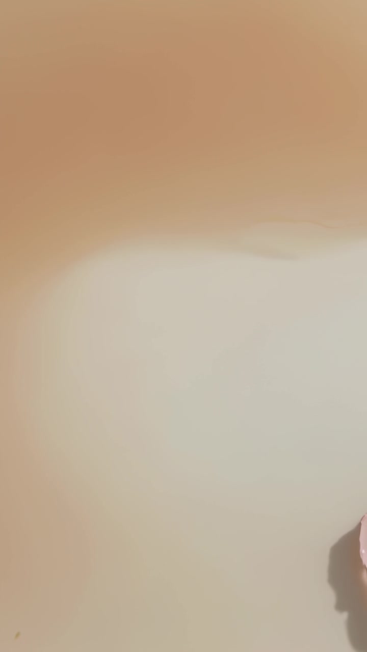 Video verticale: Panoramica della telecamera che rivela la luce su una parete beige all'interno, con modanatura e curva rosa per i dettagli.