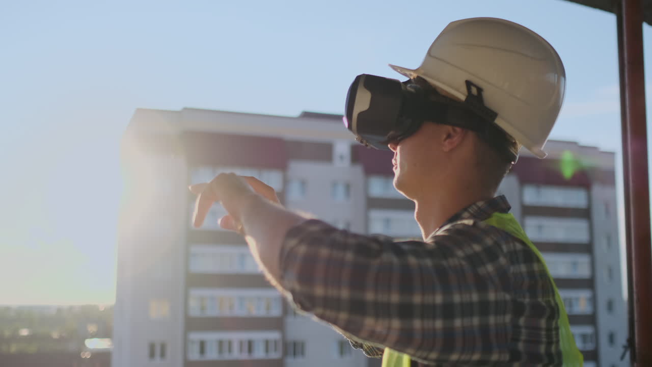 el ingeniero constructor visualiza el plan del edificio de pie en el techo del edificio al atardecer se encuentra en gafas vr y mueve sus manos usando la interfaz del futuro.
