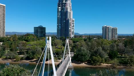 un puente peatonal que conduce a un parque cerca de una gran ciudad