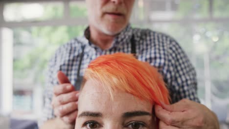 front view hairdresser arranging woman hair