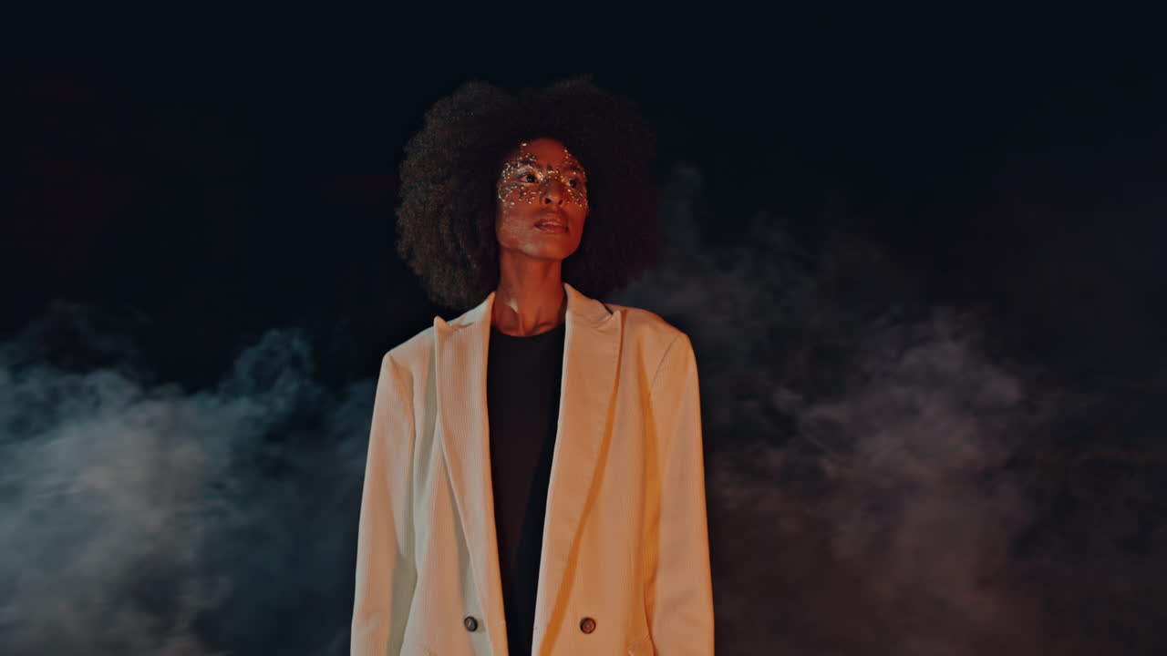 Fashion model posing smoke in black background. Attractive woman rest festival