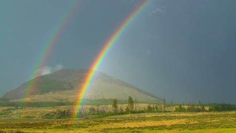 a double rainbow shines over a field