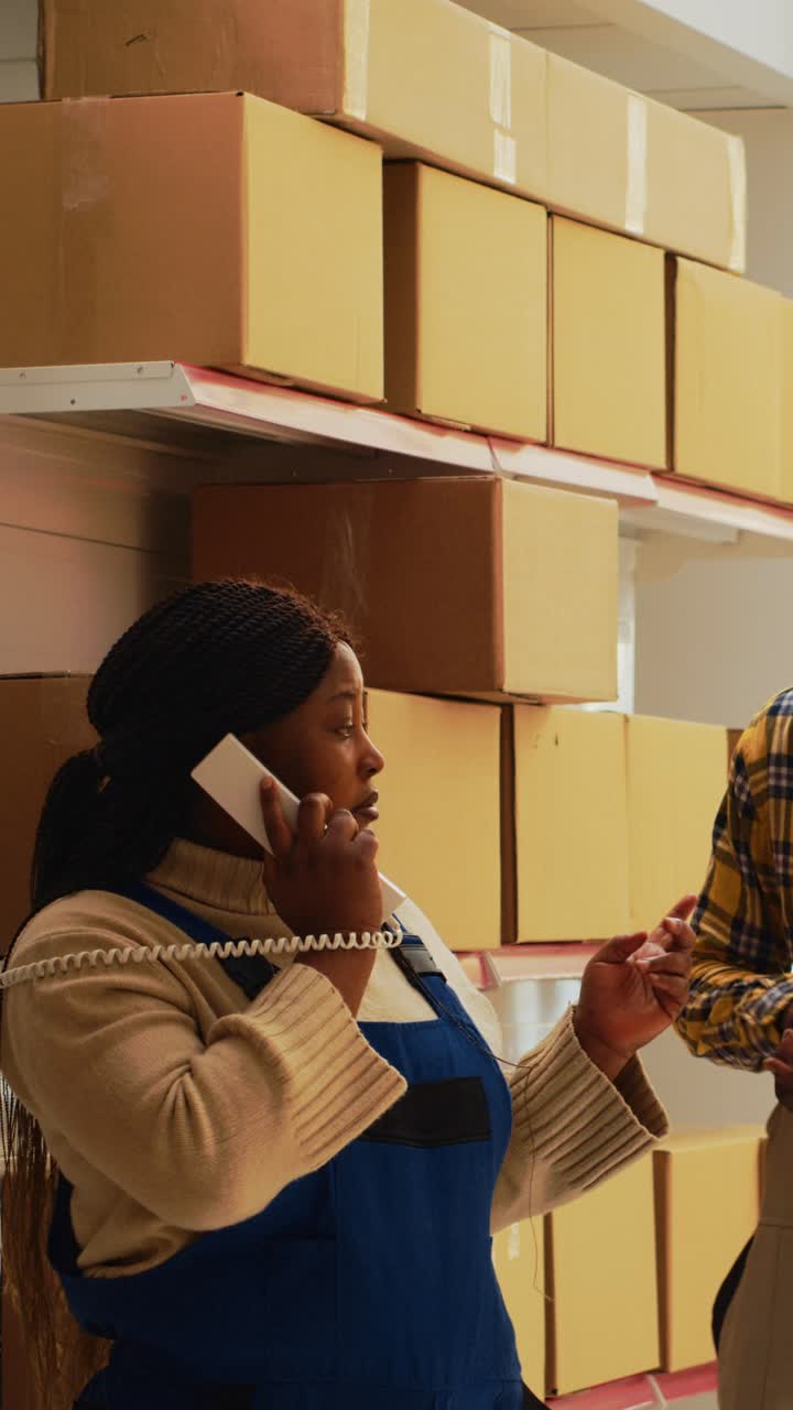 Vertical video: Depot manager answering phone call in warehouse space