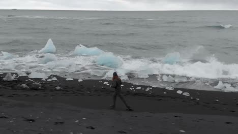 slow motion aerial shot along black sand beach