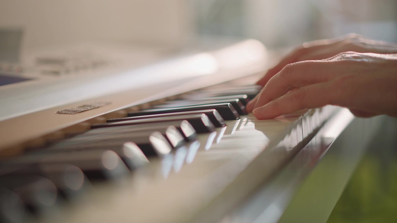 Primo piano di mani che suonano i tasti di una tastiera, movimento dettagliato delle dita e flusso dell'arpeggio, luce diurna calda, pratica paziente per sviluppare destrezza e dinamiche sottili, attenzione al tocco e al sustain.
