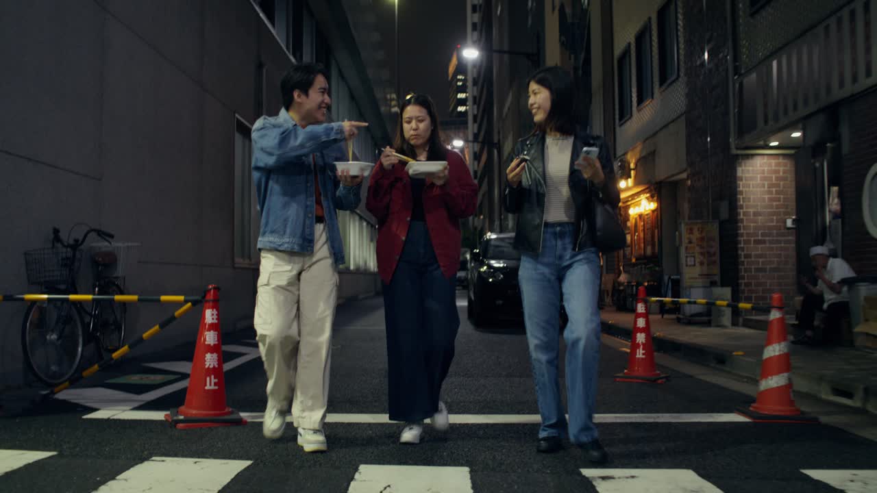 Friends enjoying dinner in a Japanese city street at night