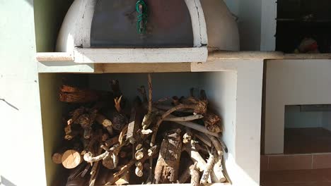 outside view of a wood oven with a firewood under it