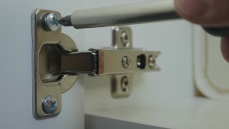 furniture assembler screws into the loop of the cabinet in the kitchen. close up. interior in the kitchen. 4k