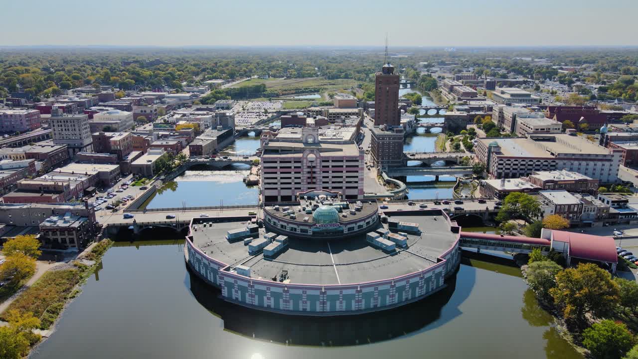 Drone footage capturing downtown Aurora, IL, a Chicago suburb in the Chicagoland area, near the river, buildings, and the Metra train line. Orbit Right Day S