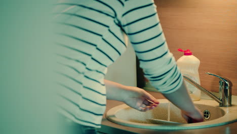 Woman-washing-dishes-in-the-kitchen-at-home