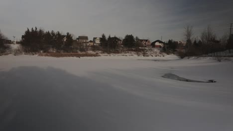 Toma-Panorámica-De-Un-Estanque-Congelado-En-Medio-De-Un-Vecindario-Suburbano