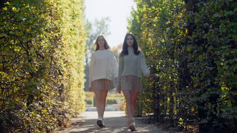 two women walking through an autumnal park
