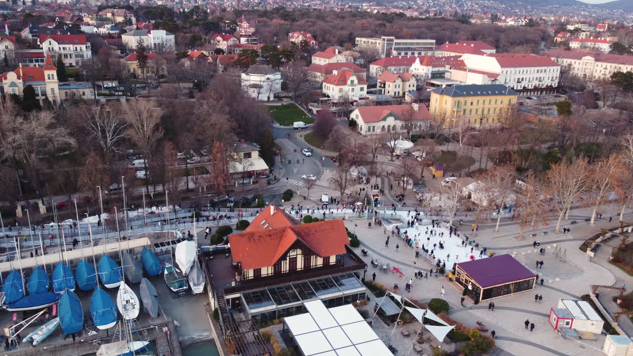 Aerial shot of town structures and nearby marina in Balatonfured under soft golden hour light