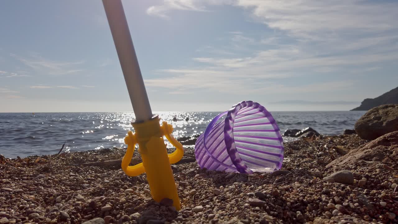 un cubo de juguete en la costa de guijarros de la playa de cabo de gata en españa