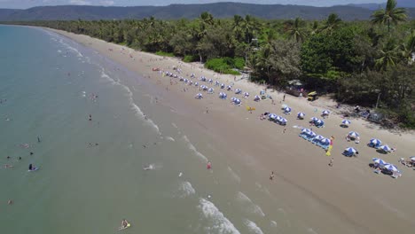 turistas disfrutando en la playa de cuatro millas en port douglas, australia - toma aérea de drones