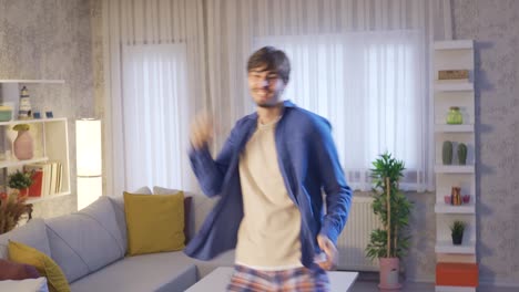 young man dancing at home and enjoying life. dancing.