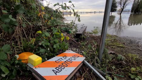 a road sign of the city of abbotsford on the ground after flooding in canada