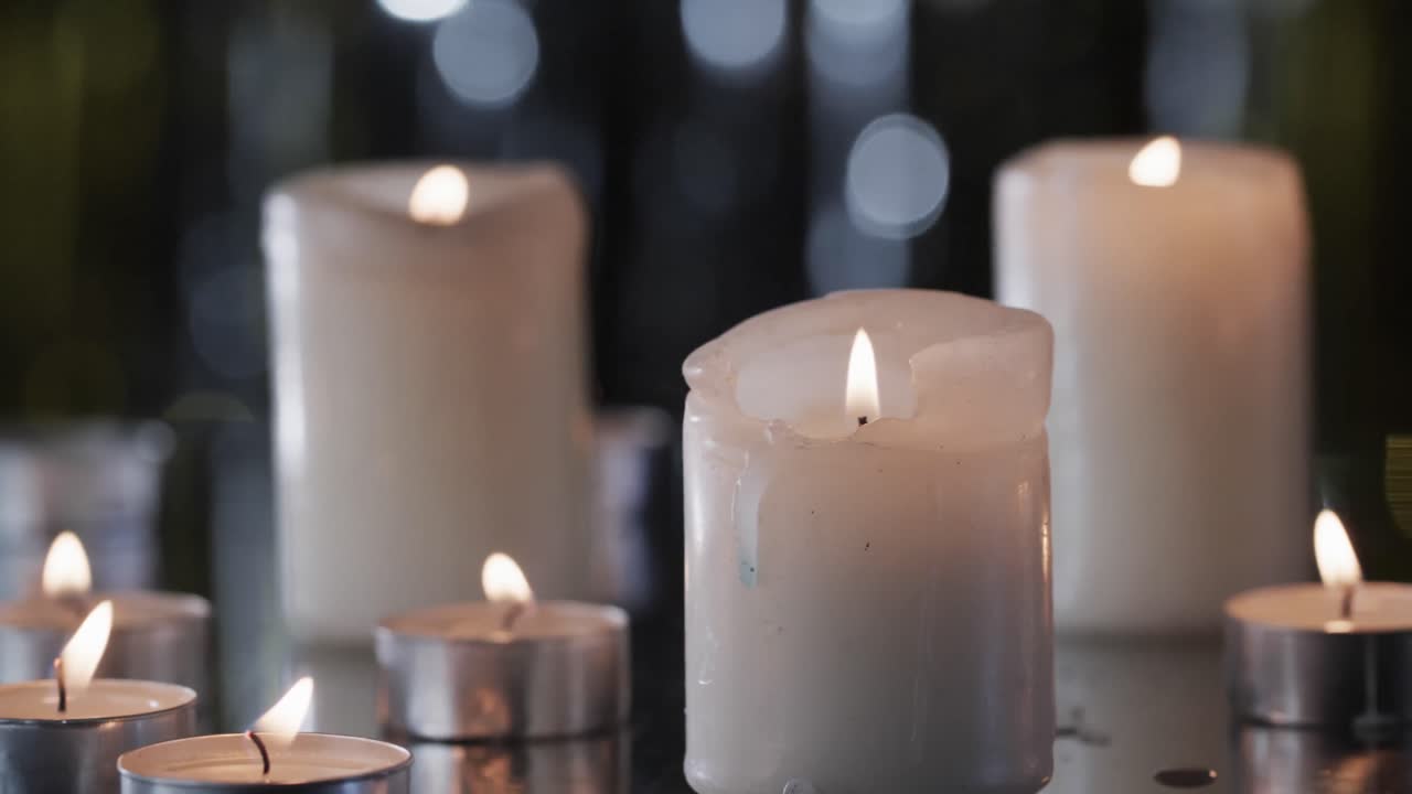Video di candele bianche con fiamme bianche e spazio per il testo con effetto bokeh su sfondo nero